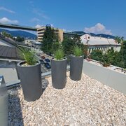 Štýlová strešná záhrada pre súkromný oddych – Moderný dizajn spája pohodlný exteriérový nábytok, zeleň v kvetináčoch a atmosférické osvetlenie pre dokonalý relax